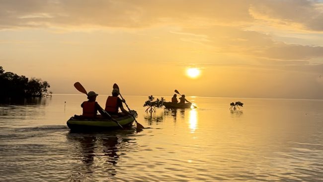 2 kayaks gonflables qui naviguent devant un couché de soleil
